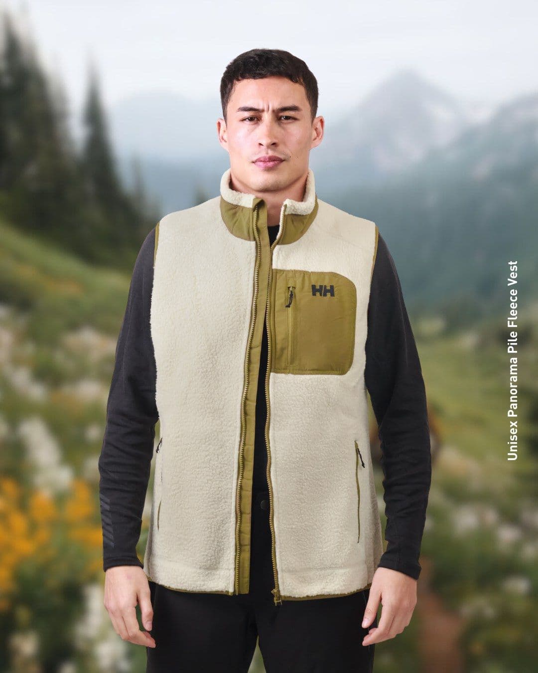 Key visual: a man in a cream Helly Hansen pile fleece vest in front of a soft-focus mountain meadow